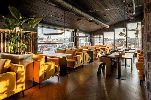 a restaurant with yellow chairs and tables and windows at Loft7 in Lviv