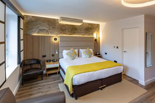 una camera d'albergo con letto e sedia di The Studley Hotel a Harrogate