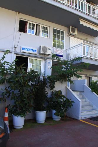 a building with potted plants in front of it at Galanis Studios and Apartments in Platamonas
