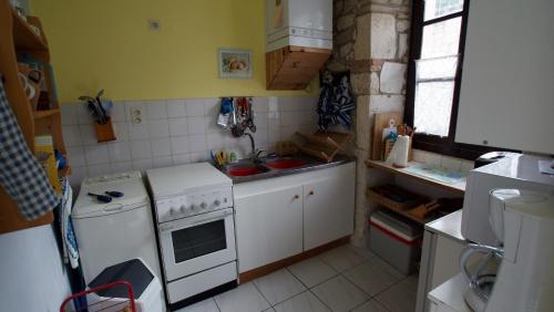 a small kitchen with a stove and a sink at Les Chimères in Puylaroque