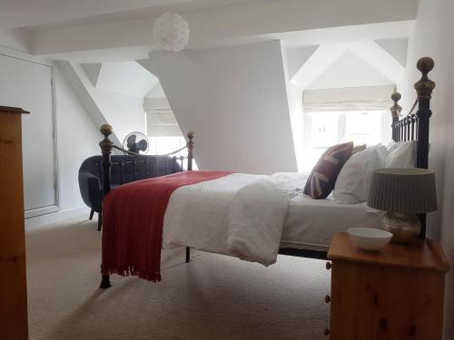 Schlafzimmer mit einem Bett mit einer roten und weißen Decke in der Unterkunft Warwick Market Place Apartment in Warwick