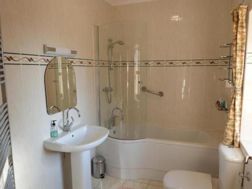 a bathroom with a sink and a shower and a tub at Blaengader Cottages - Enlli in Aberystwyth