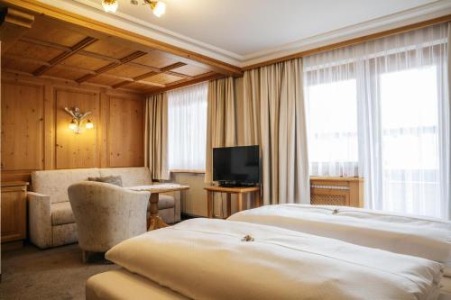 a hotel room with two beds and a television at Hotel Kristall in Lech am Arlberg