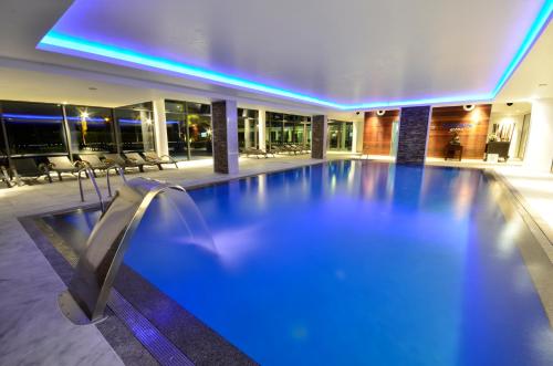 una piscina en un edificio con iluminación azul en Aquashow Park Hotel en Quarteira