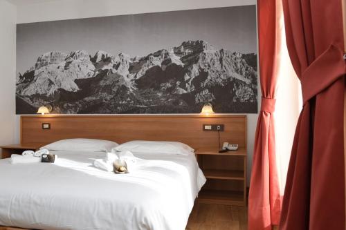 a bedroom with a large white bed with a mountain mural at Park Residence Imperator in Carisolo