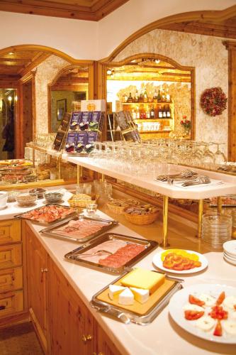 a buffet line with plates of food and glasses at Hotel Kristall in Lech am Arlberg