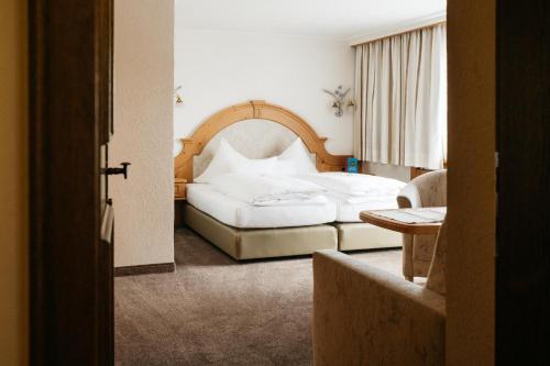 a hotel room with a bed and a chair at Hotel Kristall in Lech am Arlberg