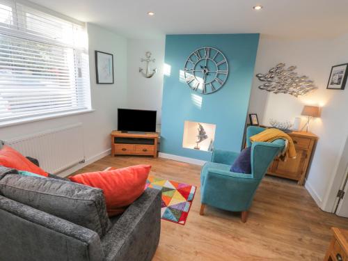a living room with a couch and two chairs at Sea Glass in Filey