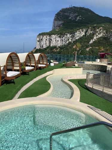 a hot tub with chairs and a mountain in the background at Luxury Ocean Spa Plaza Private Large 1 bed apartment in Gibraltar