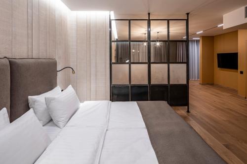 a bedroom with a white bed and a television at Loft7 in Lviv