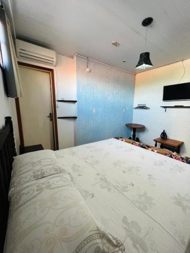 a bedroom with a large bed in a room at Pousada Rosa Center in Praia do Rosa