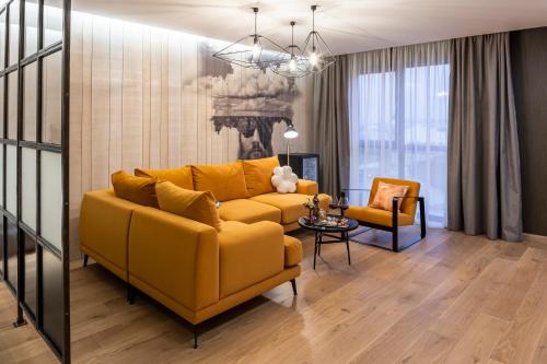 a living room with a yellow couch and a chair at Loft7 in Lviv