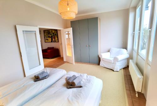 a bedroom with two beds and a chair at Penthouse Hafenblick - private Sauna - Teil der HolidayEscapes Kollektion in Travemünde