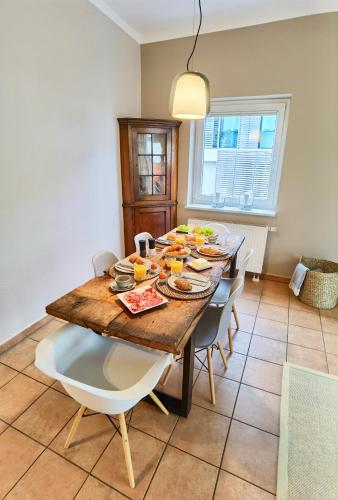 a dining room with a wooden table and chairs at Penthouse Hafenblick - private Sauna - Teil der HolidayEscapes Kollektion in Travemünde