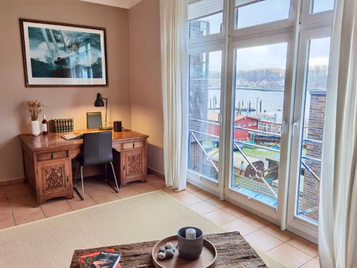 an office with a desk and a large window at Penthouse Marina - Sauna und Flussblick in Travemünde