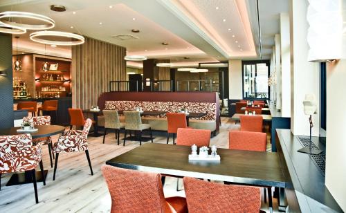a restaurant with tables and chairs and a bar at Parkhotel "Am Schänzchen" in Andernach