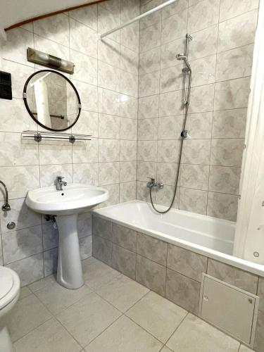 a bathroom with a sink and a tub and a toilet at Kántás Vendégház Tihany in Tihany