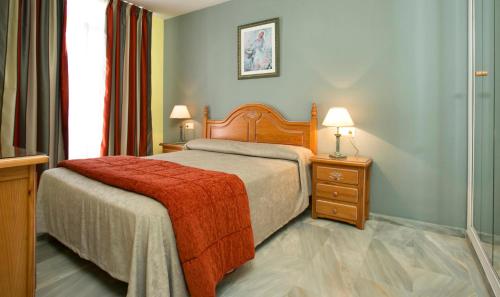 a bedroom with a bed with a red blanket at Ona Campanario in La Cala de Mijas