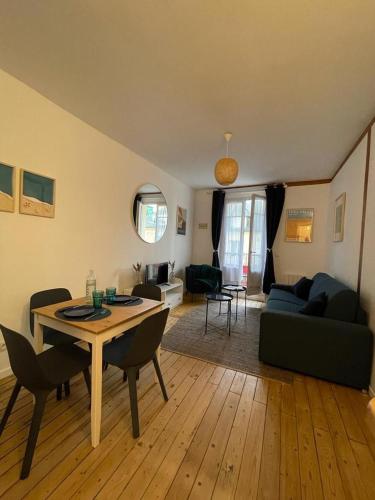 un salon avec une table et un canapé dans l'établissement Le « Blanc Bleu »-charmant 2 pièces /3 min Gare, à Trouville-sur-Mer