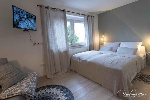 a bedroom with a white bed and a window at Sali Homes - Bergerie in Obersulm