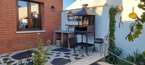 a small patio with a table and a grill at Casa Labradores Piscina, SPA, Barbacoa y Salon Juegos in Camarenilla