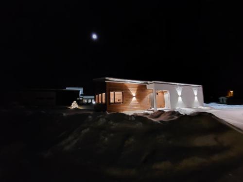 a small house in the snow at night at Arctic River Chalet in Rovaniemi