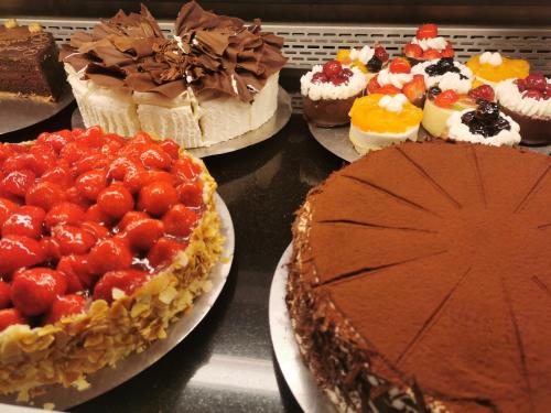a group of cakes and pies on display in a bakery at Parkhotel "Am Schänzchen" in Andernach