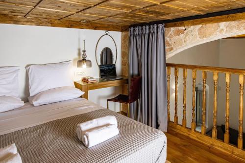 a bedroom with a bed and a wooden staircase at Melitia Traditional House in Koskinou