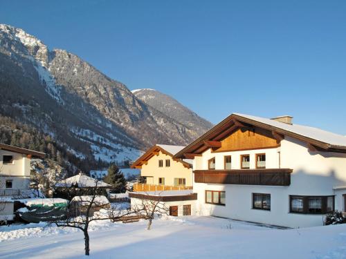 a house in the snow with mountains in the background at Apartment Köhle by Interhome in Pfunds