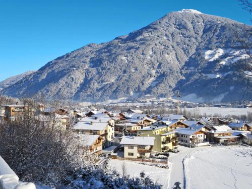 een dorp bedekt met sneeuw met een berg op de achtergrond bij Apartment Gangerhof by Interhome in Kaltenbach