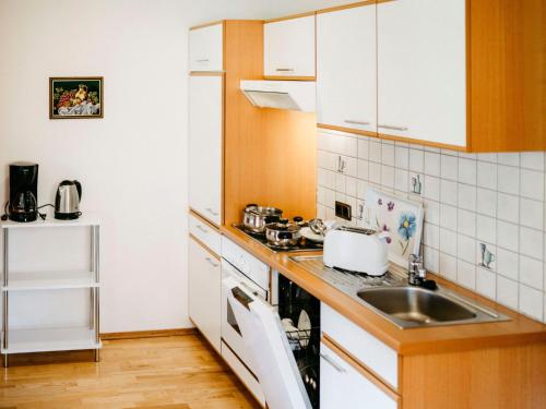 a small kitchen with a sink and a stove at Apartment Herzele by Interhome in Arriach