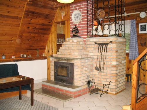 a brick fireplace in a living room with wooden ceilings at Chalet Bily - SZV100 by Interhome in Střížovice