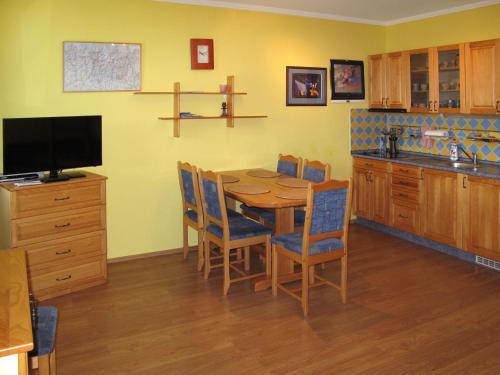 a kitchen with a wooden table with chairs and a television at Apartment Horní Mísečky - HMS110 by Interhome in Vítkovice