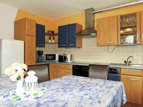 kuchnia ze stołem, na którym stoi wazon z kwiatami w obiekcie Apartment Max by Interhome w mieście Winkle
