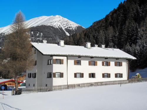 a building in the snow with a mountain in the background at Apartment Altes Zollhaus-4 by Interhome in Nauders