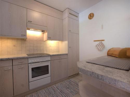 a kitchen with white cabinets and a counter top at Apartment Chesa Flora 53 by Interhome in St. Moritz