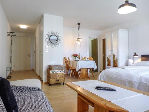 1 dormitorio con 1 cama y comedor con mesa en Apartment Chesa Ova Cotschna 303 by Interhome, en St. Moritz