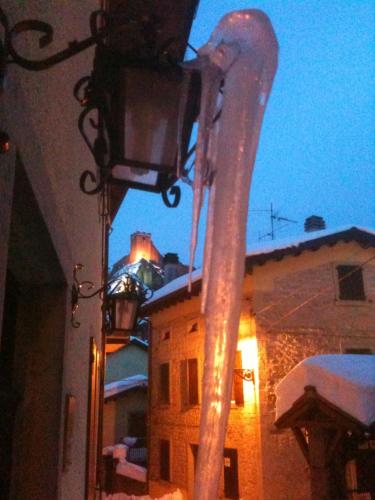 a street light on the side of a building with snow at Hotel Regina in Sestola