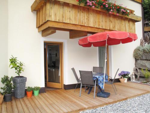 patio ze stołem, krzesłami i parasolem w obiekcie Apartment Bergfeld - SIX171 by Interhome w mieście Spiss