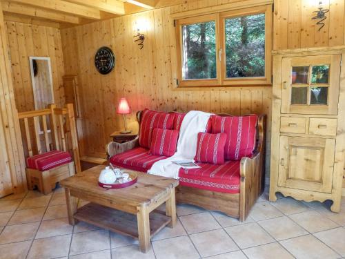 a living room with a red couch and a table at Chalet Evasion by Interhome in Les Bossons