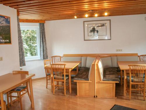 a dining room with wooden tables and chairs at Apartment Helga - TDL113 by Interhome in Tobadill