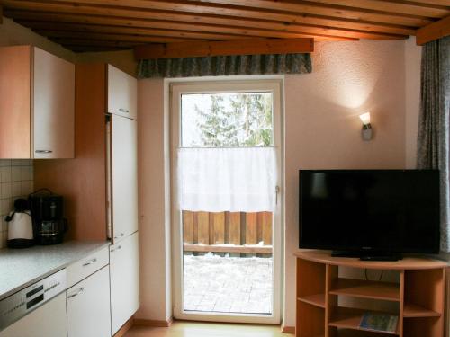 eine Küche mit einem TV und einem großen Fenster in der Unterkunft Apartment Helga - TDL113 by Interhome in Tobadill