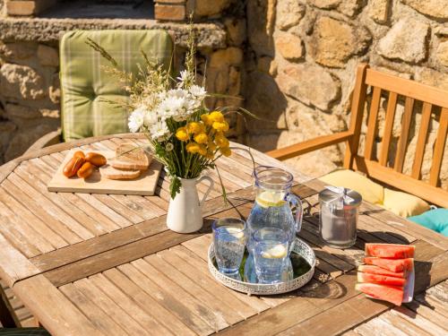 a table with a vase of flowers and drinks on it at Holiday Home Bila Retreat with Pool by Interhome in Blažejov