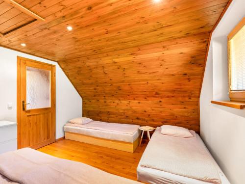 a room with two beds and a wooden ceiling at Holiday Home Bila Retreat with Pool by Interhome in Blažejov