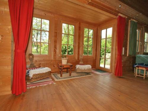 a living room with wooden walls and windows at Holiday Home Haus Fries by Interhome in Unterbergern