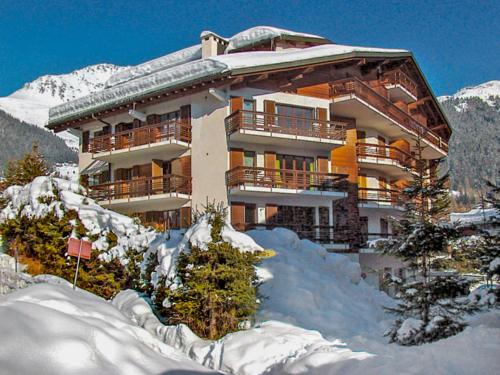 a large building with snow in front of it at Apartment Galaxie 218 by Interhome in Verbier