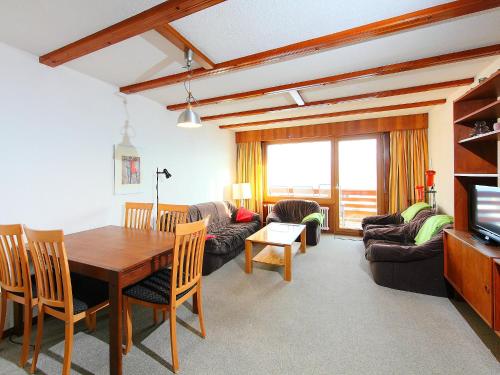 uma sala de estar com uma mesa de jantar e um sofá em Apartment Porthos 37 by Interhome em Verbier