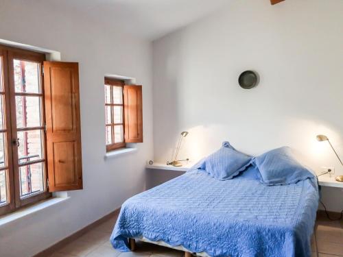 - une chambre avec un lit avec une couette bleue et 2 fenêtres dans l'établissement Holiday Home Maury by Interhome, à Grimaud