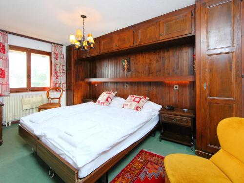 ヴェルビエにあるApartment Mirador 186 by Interhomeの木製の壁のベッドルーム1室(大型ベッド1台付)