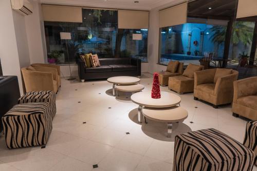 a lobby with tables and chairs and a couch at Hotel Embajador in San Miguel de Tucumán